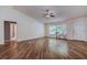 Spacious living room with wood-look floors, a ceiling fan, and a large window for natural light at 3647 Lake St George Dr, Palm Harbor, FL 34684