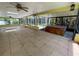 Large screened-in lanai with tile floors, a hot tub, and multiple ceiling fans for comfortable outdoor living at 3647 Lake St George Dr, Palm Harbor, FL 34684