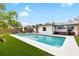 Relaxing backyard with an inviting swimming pool and lounge chairs on the manicured lawn creating a private oasis at 416 Graham Dr, Clearwater, FL 33765