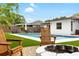 Scenic pool area with Adirondack chairs and a charming fire pit, perfect for outdoor relaxation and gatherings at 416 Graham Dr, Clearwater, FL 33765