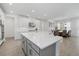 A modern kitchen island with quartz countertop next to a dining area with backyard views at 4423 Pond Brook Ct, Bradenton, FL 34211