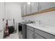 Well-equipped laundry room with gray cabinets, a sink, and modern washer and dryer at 4423 Pond Brook Ct, Bradenton, FL 34211
