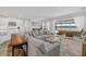 Open-concept living space with modern decor, a large sofa, and view of dining area and pool at 4423 Pond Brook Ct, Bradenton, FL 34211