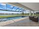 Screened-in pool area with hot tub and lounge seating with water view at 4423 Pond Brook Ct, Bradenton, FL 34211