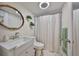 Bright bathroom featuring white vanity, oval mirror, and shower with curtain at 5108 26Th Street W Ct, Bradenton, FL 34207