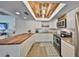 Modern kitchen features white cabinets, stainless appliances, granite countertops, and unique wood-paneled ceiling at 5108 26Th Street W Ct, Bradenton, FL 34207