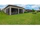Large grassy backyard featuring a covered patio, screened-in patio, and other backyard structures at 5128 Dockyard Pl, Land O Lakes, FL 34638