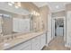 Bright bathroom offers dual sinks, a spacious walk-in shower, and a door leading to a large walk-in closet at 5128 Dockyard Pl, Land O Lakes, FL 34638