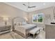 Relaxing bedroom with neutral tones, a tufted headboard, and a cozy bench at the foot of the bed at 5128 Dockyard Pl, Land O Lakes, FL 34638