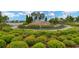 Beautifully landscaped entrance to the community featuring a lake, waterfall feature, and lush greenery at 5128 Dockyard Pl, Land O Lakes, FL 34638