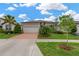 Charming single-story home with brick driveway, lush landscaping, and a two-car garage at 5128 Dockyard Pl, Land O Lakes, FL 34638