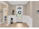 Inviting foyer with decorative front door, wood-look flooring, and elegant wainscoting at 5128 Dockyard Pl, Land O Lakes, FL 34638