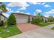 Charming one-story home boasts a brick driveway, attached garage, and manicured landscaping at 5128 Dockyard Pl, Land O Lakes, FL 34638