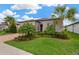 Beautiful home featuring lush landscaping, palm trees, and a welcoming front yard at 5128 Dockyard Pl, Land O Lakes, FL 34638