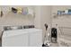 Functional laundry room with a washer, dryer, storage shelves, and other organizational supplies at 5128 Dockyard Pl, Land O Lakes, FL 34638