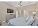 This primary bedroom features a dresser with mounted television, an ensuite bath, and neutral décor at 5128 Dockyard Pl, Land O Lakes, FL 34638