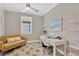 Bright office features a modern yellow couch, a white desk, and lots of natural light from the window at 5128 Dockyard Pl, Land O Lakes, FL 34638