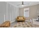 The bright office features a mod yellow loveseat, a white desk, and a textured rug at 5128 Dockyard Pl, Land O Lakes, FL 34638