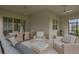 Covered patio area furnished with comfortable seating, ceiling fans, and an outdoor dining table at 5128 Dockyard Pl, Land O Lakes, FL 34638
