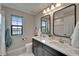 Bathroom with a double vanity, framed mirrors, modern fixtures, and a window for natural light at 5601 Limelight Dr, Apollo Beach, FL 33572