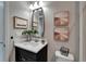 Updated bathroom with black vanity, white counters, framed mirror, and stylish decor at 5601 Limelight Dr, Apollo Beach, FL 33572