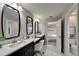 Bright bathroom featuring double vanity with modern sinks, mirrors, and an open doorway leading to the bedroom and water closet at 5601 Limelight Dr, Apollo Beach, FL 33572