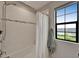 Bathroom showing white tiled walls, a shower and a window for natural light at 5601 Limelight Dr, Apollo Beach, FL 33572