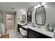 Bright bathroom featuring double vanity with modern sinks, mirrors, and a glass shower with an open doorway to a walk-in closet at 5601 Limelight Dr, Apollo Beach, FL 33572