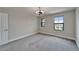 Bedroom with neutral walls, carpet and two windows overlooking the neighborhood at 5601 Limelight Dr, Apollo Beach, FL 33572
