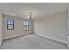 Bedroom with neutral walls, carpet, a modern light fixture and two windows for natural light at 5601 Limelight Dr, Apollo Beach, FL 33572