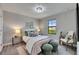 This bedroom features neutral walls, a window, chandelier lighting, and an upholstered headboard at 5601 Limelight Dr, Apollo Beach, FL 33572