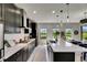 Modern kitchen with sleek black cabinetry, white countertops, stainless steel appliances, and an island with a sink at 5601 Limelight Dr, Apollo Beach, FL 33572