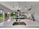 Kitchen island with a sink and stylish pendant lights, with views of the dining and living area at 5601 Limelight Dr, Apollo Beach, FL 33572