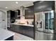 Stainless steel refrigerator and wall oven complement modern kitchen with granite counters and dark cabinetry at 5601 Limelight Dr, Apollo Beach, FL 33572