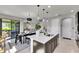 Bright kitchen featuring an island with a sink, pendant lighting, and an adjacent dining area and living space at 5601 Limelight Dr, Apollo Beach, FL 33572