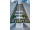Striking view of condo tower entrance with manicured landscaping, stairs, and a clear view of the building's architecture at 7050 Sunset S Dr # 912, South Pasadena, FL 33707