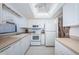 Well-lit kitchen with white cabinetry, countertops, and appliances with tile flooring at 7050 Sunset S Dr # 912, South Pasadena, FL 33707