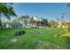 Spacious backyard with lush green lawn, mature trees, a fire pit, and a charming two-story home at 8013 Linesider Dr, Riverview, FL 33578