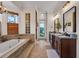 Bright bathroom featuring a soaking tub, glass block window and double vanity with granite countertop at 8013 Linesider Dr, Riverview, FL 33578