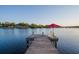 Waterfront property featuring a private wooden dock with chairs and umbrella, perfect for relaxing by the water at 8013 Linesider Dr, Riverview, FL 33578