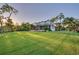 Charming two-story home with white siding, screened porch, mature trees and a lush green lawn at 8013 Linesider Dr, Riverview, FL 33578