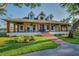 Captivating home with a welcoming front porch, rocking chairs, and beautiful green landscaping at 8013 Linesider Dr, Riverview, FL 33578
