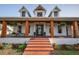 Eye-level view of a lovely front porch featuring brick steps and charming wooden columns at 8013 Linesider Dr, Riverview, FL 33578