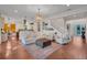 Open living room with hardwood floors, connecting to kitchen and staircase at 8013 Linesider Dr, Riverview, FL 33578