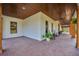 Relaxing covered side patio with rocking chairs, brick flooring, and wooden beams at 8013 Linesider Dr, Riverview, FL 33578