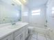 Well-lit bathroom with a vanity, toilet, and bathtub with white tile at 9101 86Th Ave, Seminole, FL 33777