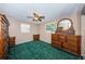 Bedroom with green carpet, ceiling fan, and wood furniture with an oval mirror at 9101 86Th Ave, Seminole, FL 33777