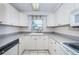 Bright kitchen features white cabinetry, a window, and neutral countertops and flooring at 9101 86Th Ave, Seminole, FL 33777
