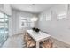 Bright dining room with a modern chandelier, a long table, and sliding glass doors to the outdoors at 10388 Sun Isle Dr, Englewood, FL 34223