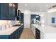 Open concept kitchen featuring a large island, navy cabinets, stainless steel appliances, and pendant lighting at 10388 Sun Isle Dr, Englewood, FL 34223